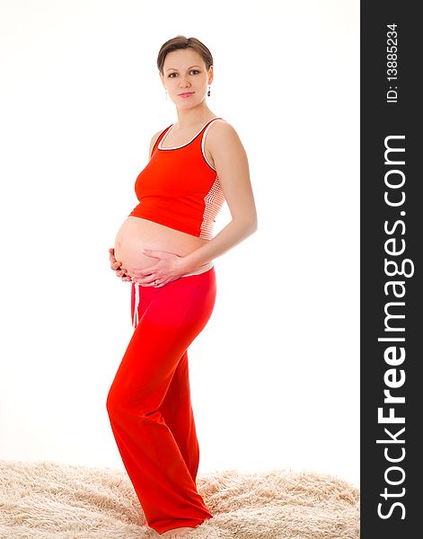 Beautiful pregnant woman in the red on a white background