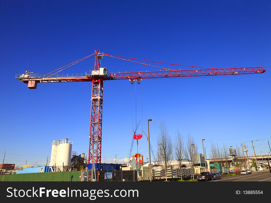 A large crane moving equipment around in the construction yard. A large crane moving equipment around in the construction yard.