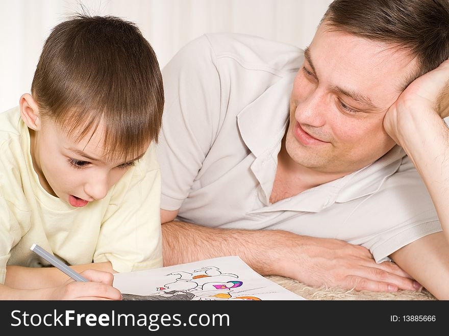 Father and son lying on the carpet and fight on his hands. Father and son lying on the carpet and fight on his hands