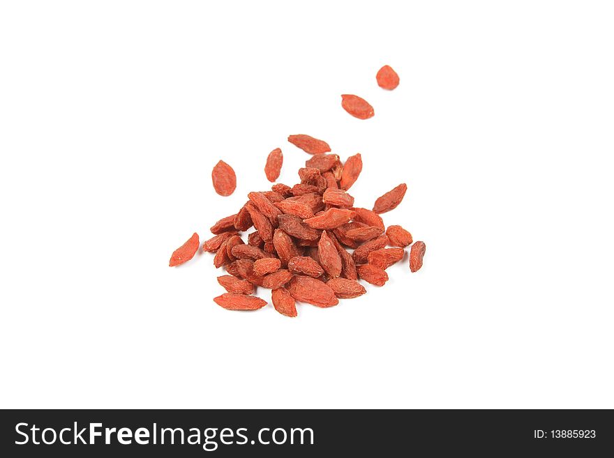 Pile of red dry goji berries on a reflective white background