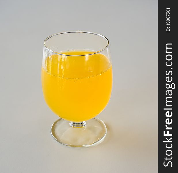 A glass cup with orange juice.