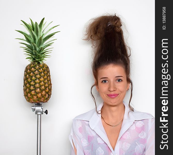 Young pretty girl with a pineapple next to her. Young pretty girl with a pineapple next to her