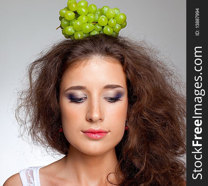 Beautiful girl with brown curly hair and grapes. Beautiful girl with brown curly hair and grapes