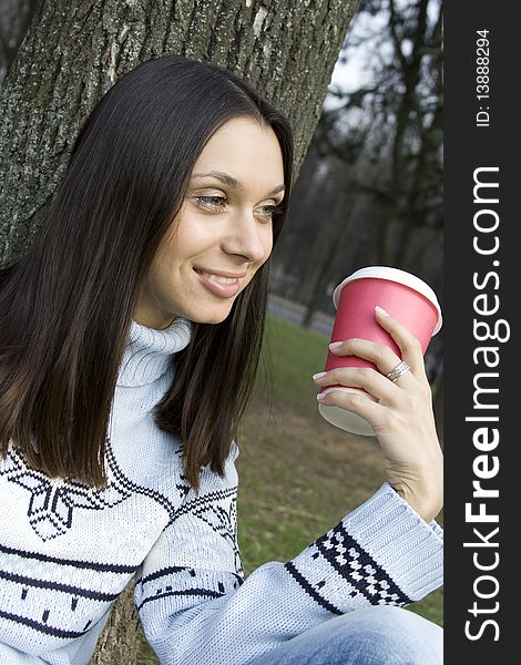 Beautiful girl sunny day in the park drinking coffee from paper cups. Portrait. Beautiful girl sunny day in the park drinking coffee from paper cups. Portrait