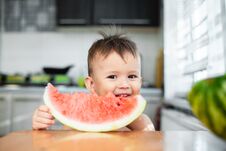 Cute Little Boy Eating Watermelon In The Kitchen Royalty Free Stock Images