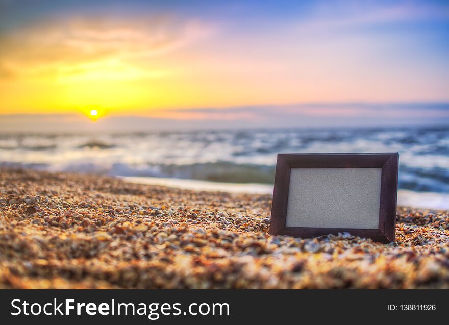 Photo frame on sand background in summer, sea at sunset place for lettering, copy space