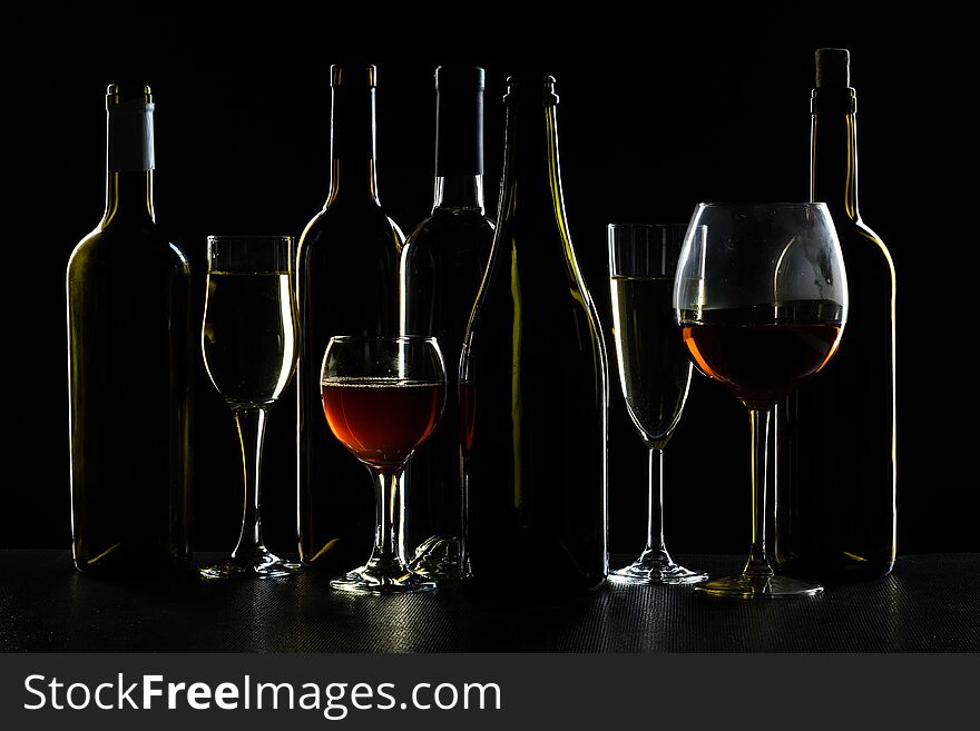 Bar Concept with a Wine Bottle, a Wine Glass and a Cocktail on a Black Background. Bar Concept with a Wine Bottle, a Wine Glass and a Cocktail on a Black Background