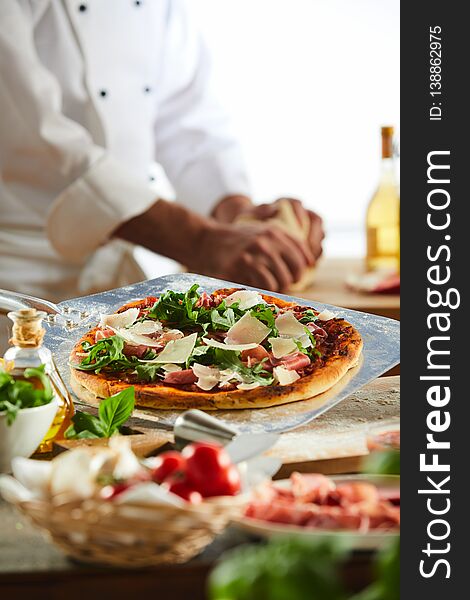 Chef Seasoning A Pizza In A Pizzeria