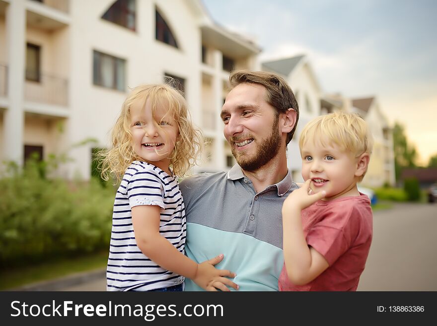 Young happy father with two cute little children walking in summer