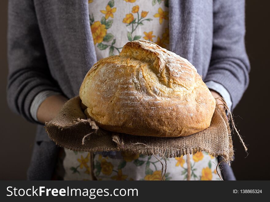 Girl baker holding fresh white bread. Girl baker holding fresh white bread