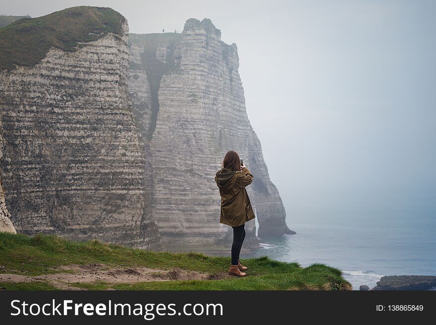 Girl standing at the edge of rock in the Etretat. France. Girl standing at the edge of rock in the Etretat. France