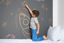 Little Child Drawing Rocket With Chalk On Wall Royalty Free Stock Photography