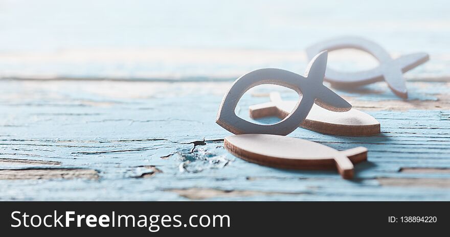 Catholic fish symbols on old wooden surface