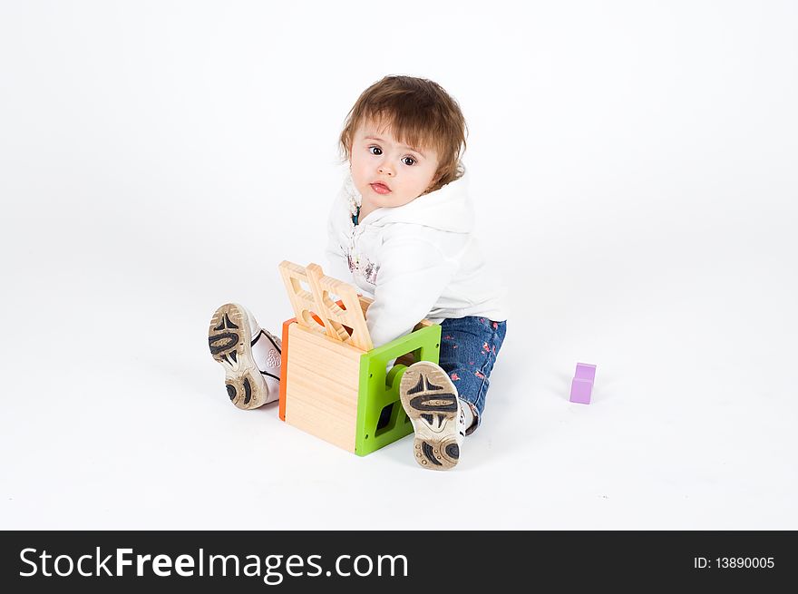 Serious Little Girl Playing With Wooden Puzzle Cub