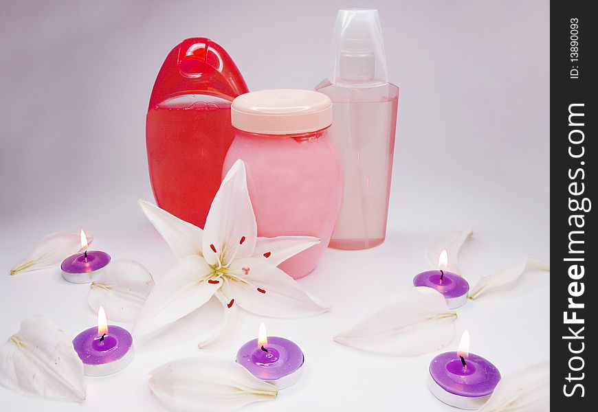 Spa hair mask creme shower gel lavender candles among white lilies. Spa hair mask creme shower gel lavender candles among white lilies