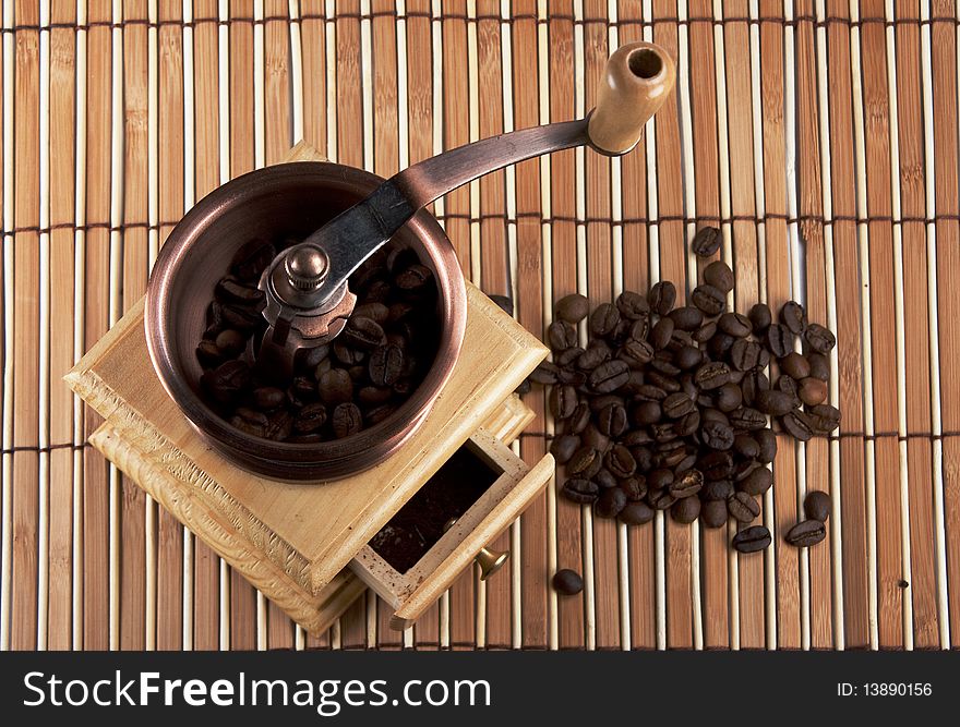 Coffee grinder with coffee grains on napkins from a tree