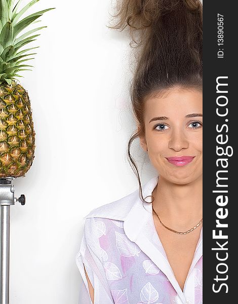 Young pretty girl with a pineapple next to her. Young pretty girl with a pineapple next to her