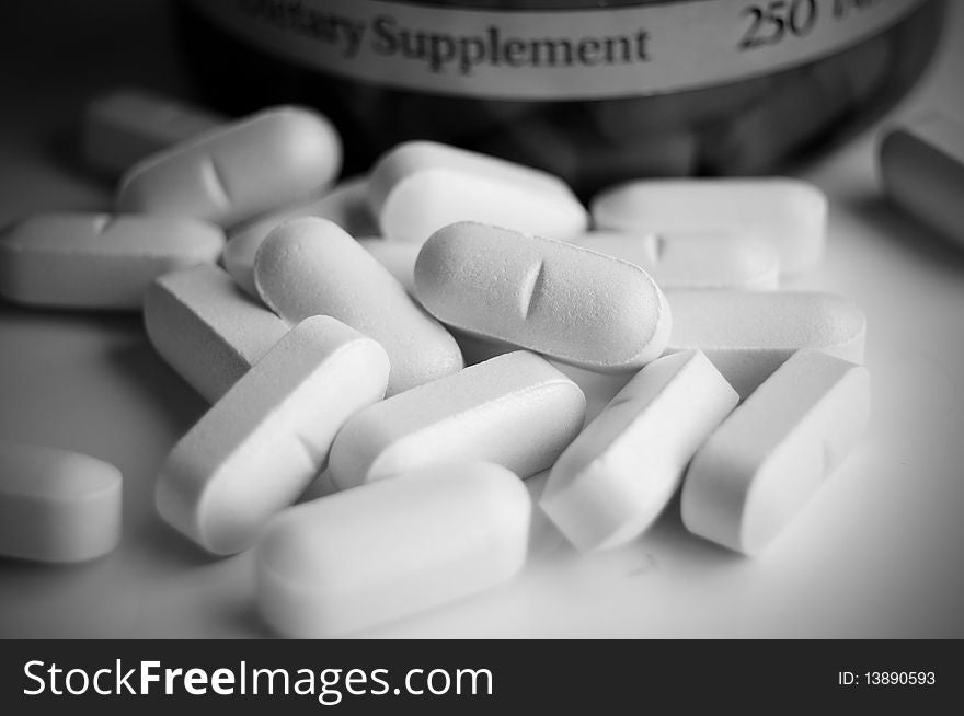 Close up picture of vitamin pills on white background