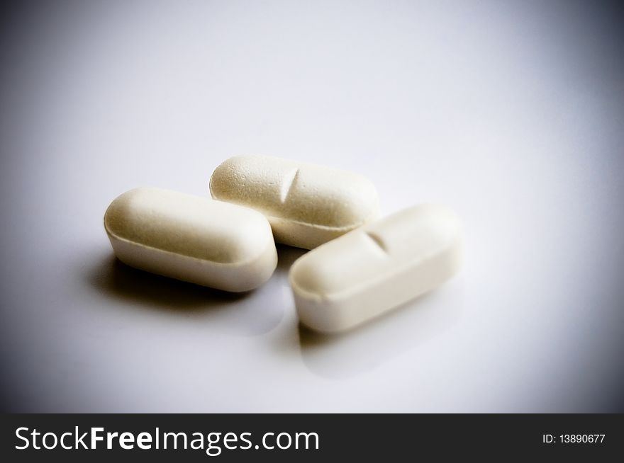 Close up picture of vitamin pills on white background