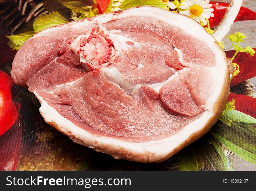 A piece of raw meat at a plural background. A piece of raw meat at a plural background