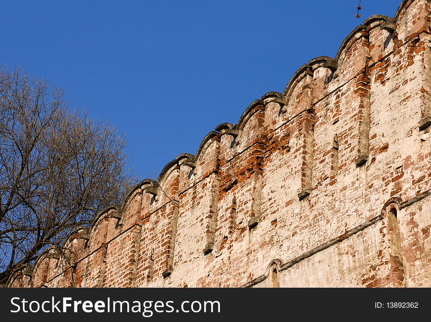 Old castle brick wall on blue sky. Old castle brick wall on blue sky