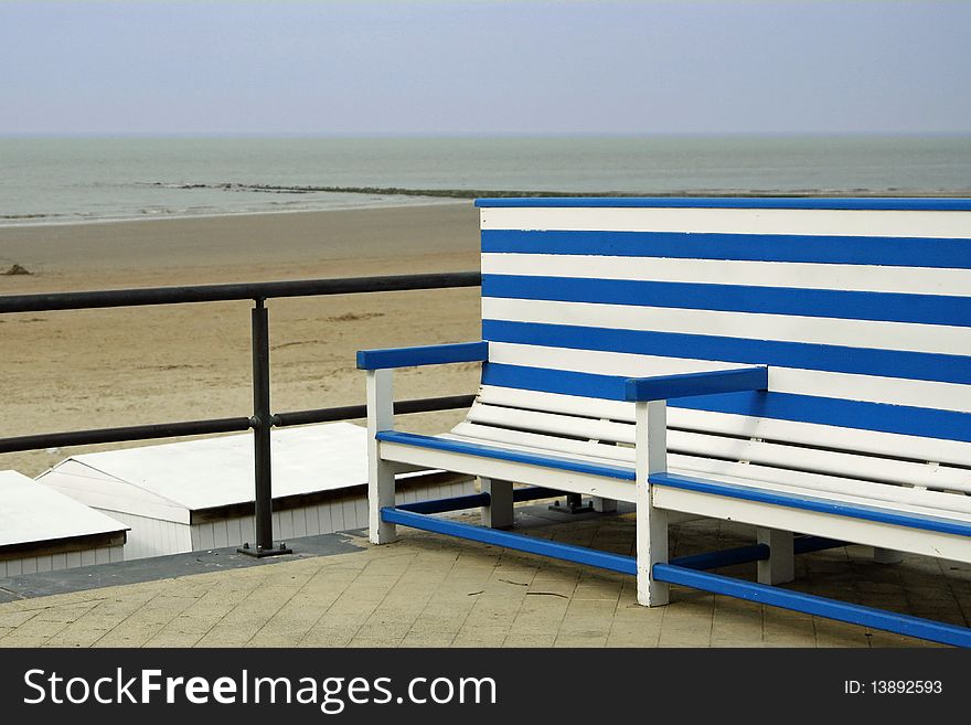 White and blue striped bench with view on sea in the background. White and blue striped bench with view on sea in the background