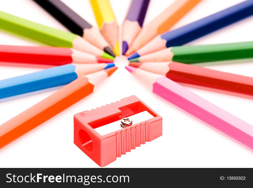 Close-up image of multicolor pencils and red sharpener isolated on white background