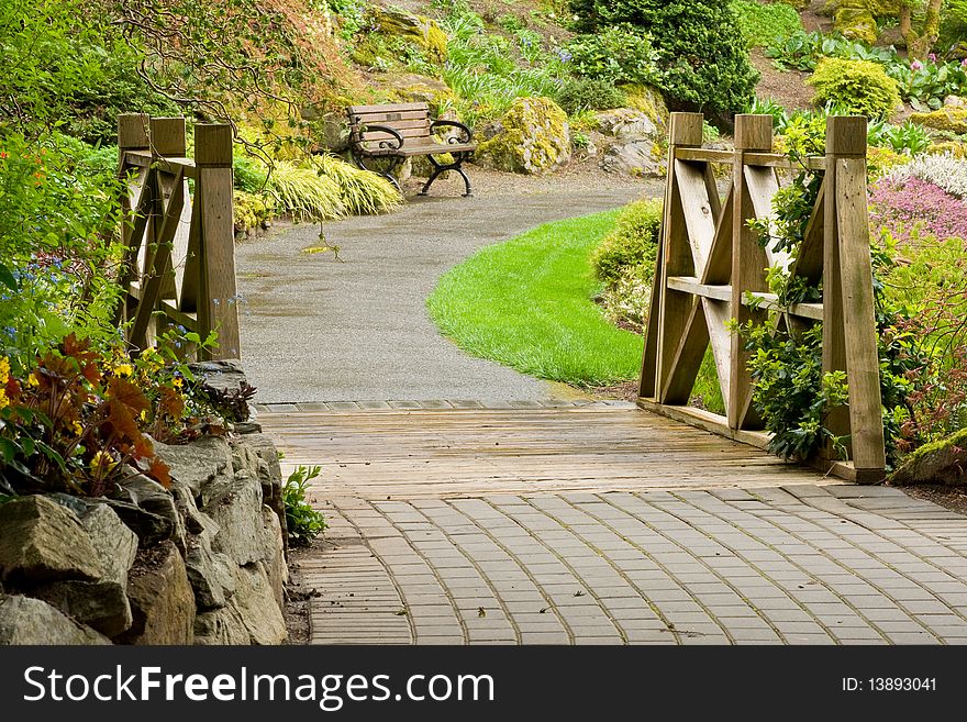 A curved garden pathway crosses a small bridge