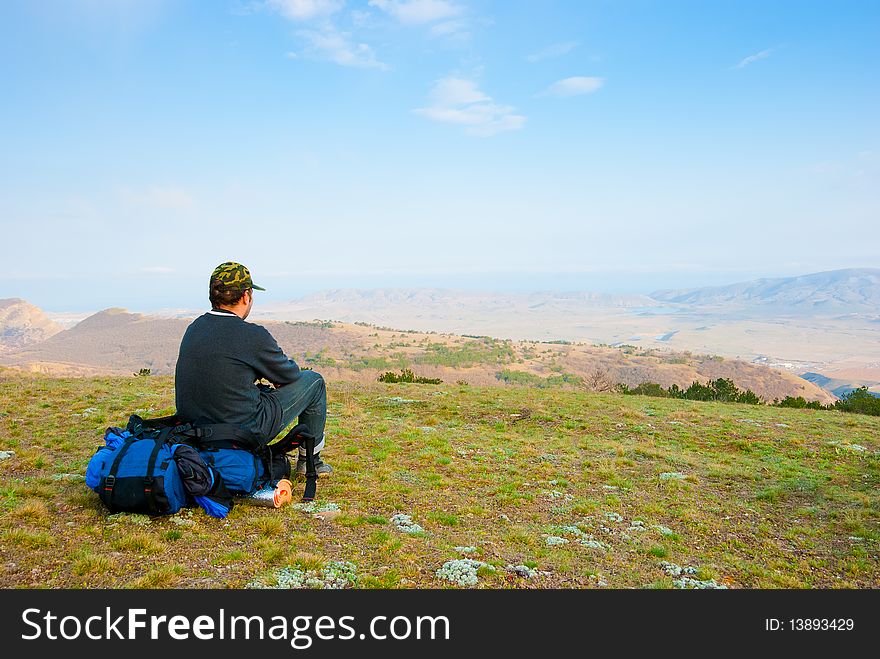 Hiker sits on the slope and enjoy the scenery