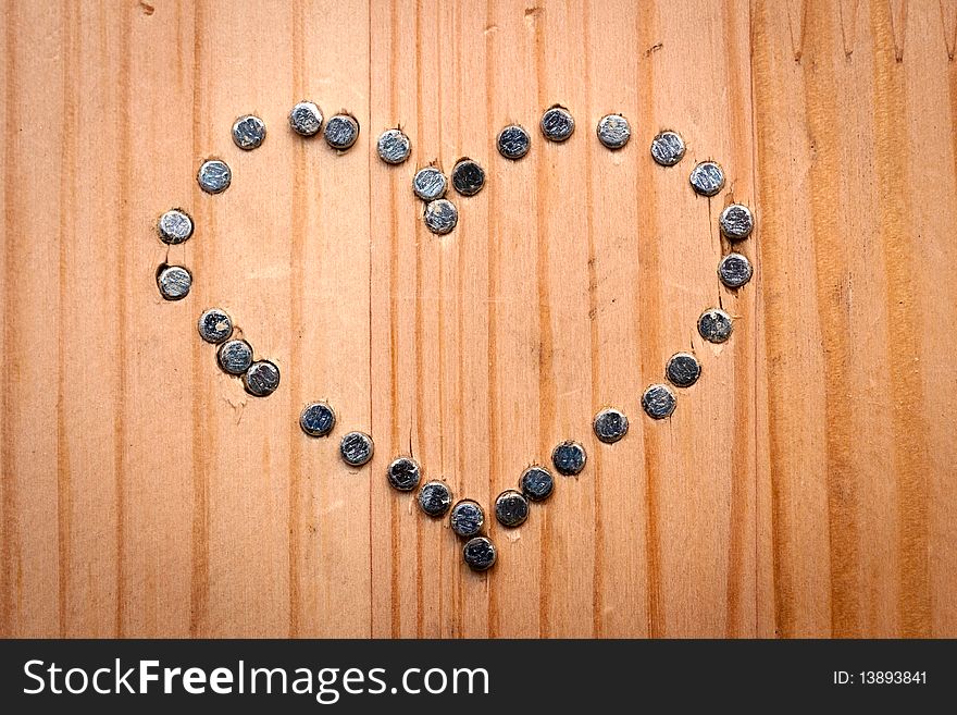 A heart from nails  on wooden desk