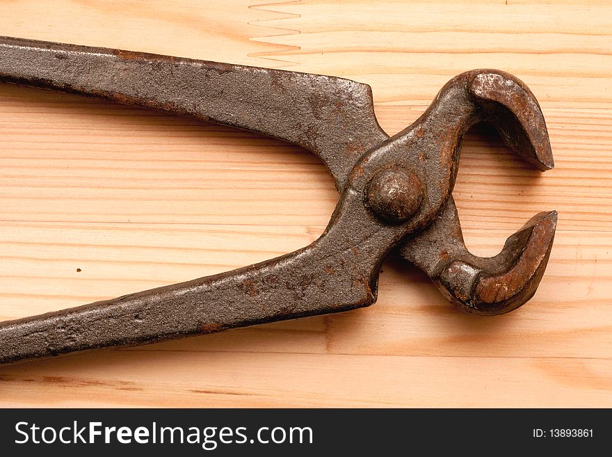 Old tongs on wooden texture