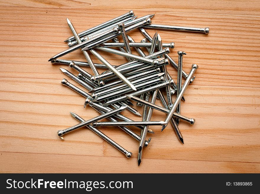 A heap of nails on wooden texture