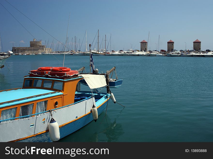 View to the harbour with the fortress and windmills in Rhodes in Greece