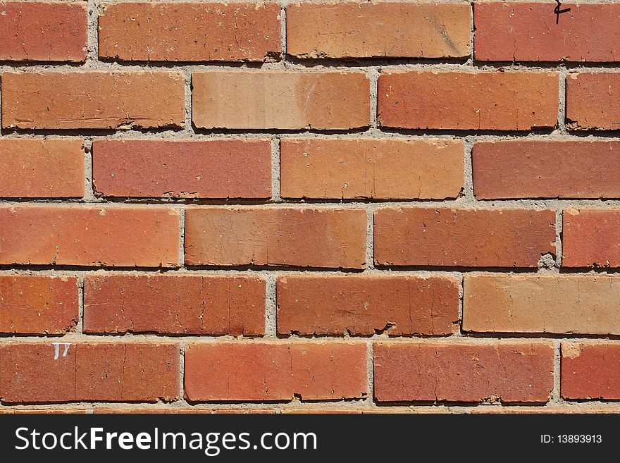 A reddish and orange colored brick wall. A reddish and orange colored brick wall