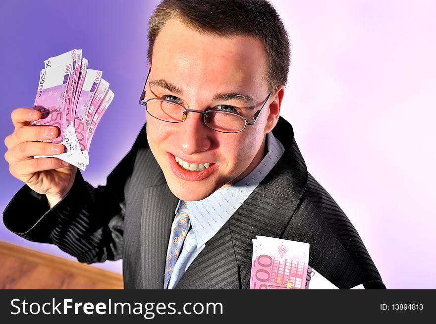 Picture shows a young businessman wearing glasses, holding a lot of money. Picture shows a young businessman wearing glasses, holding a lot of money.