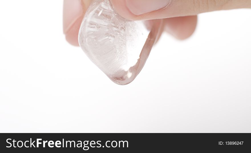 A person holding a clear ice cube which is melting. A person holding a clear ice cube which is melting.