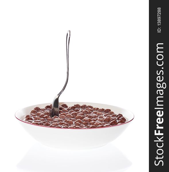 Spoon in a bowl of milk and chocolate cereal with a white background