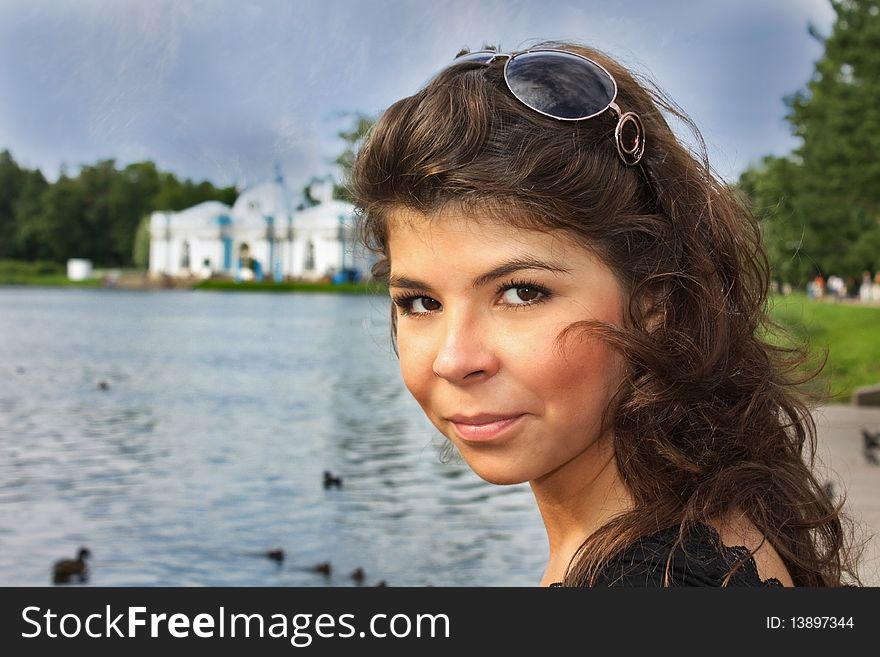 Face of the woman with sunglasses near the pond