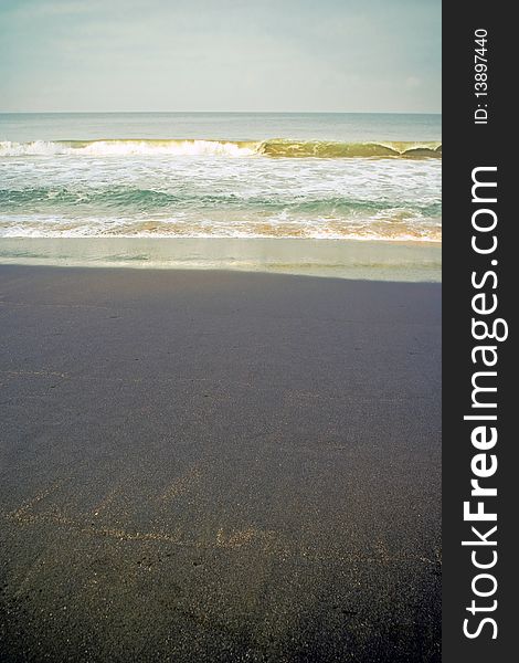 Indian seaside with black sand. Waves coming.