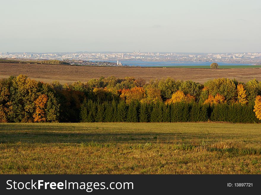 Far on horizon the city, behind fields is visible. Far on horizon the city, behind fields is visible.