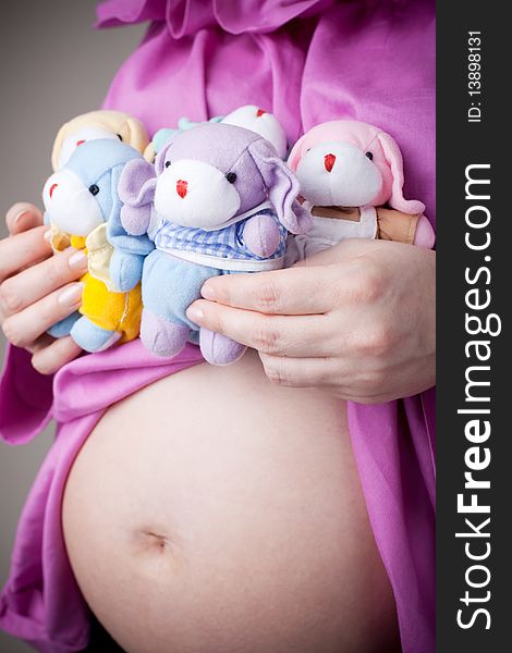 Teddy bears sitting on pregnant belly studio portret