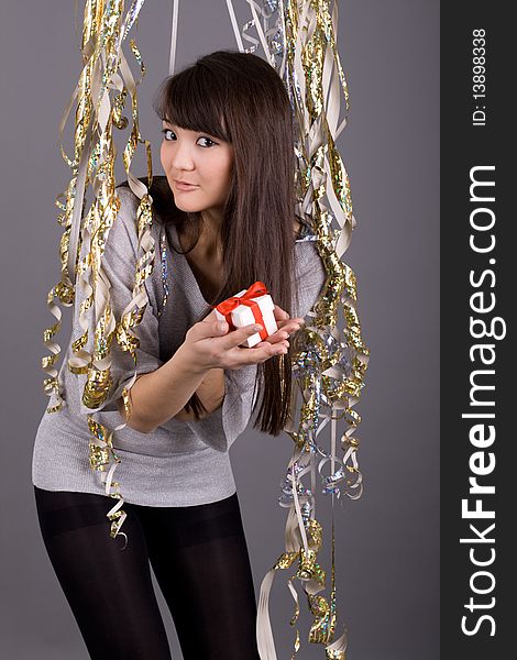 Girl standing among tinsel with box