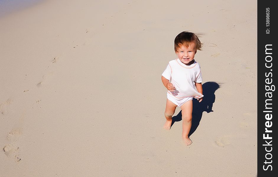Charming little girl running on the golden beaches