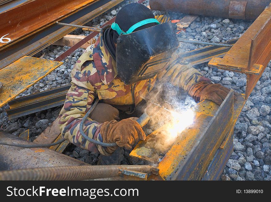 Welder in protective mask welding metal construction on open air. Welder in protective mask welding metal construction on open air