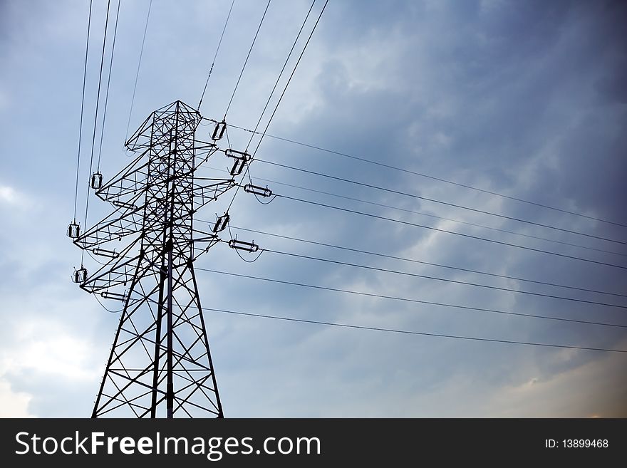 Silhouette of electrical pylon and blue sky