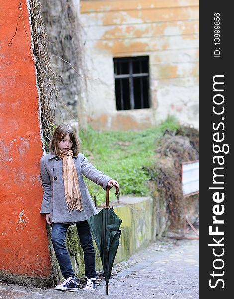 Single child standing near painted old wall. Single child standing near painted old wall