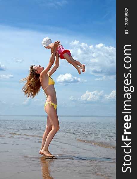 Young happy mother abandons a baby on a beach. Young happy mother abandons a baby on a beach