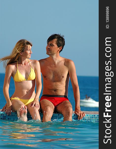 Man And Woman Sits Beside Water Pool