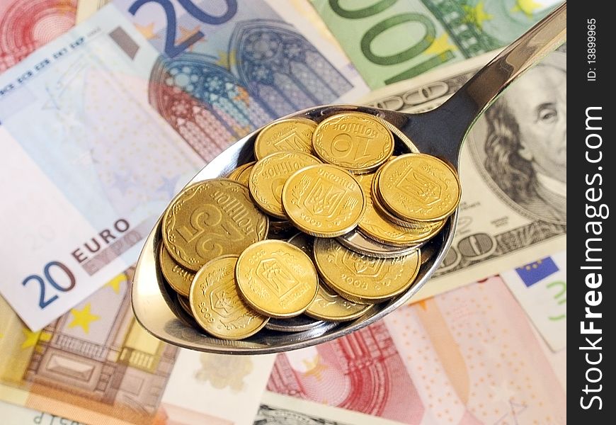 Coins in a spoon over dollar an euro banknotes. Coins in a spoon over dollar an euro banknotes