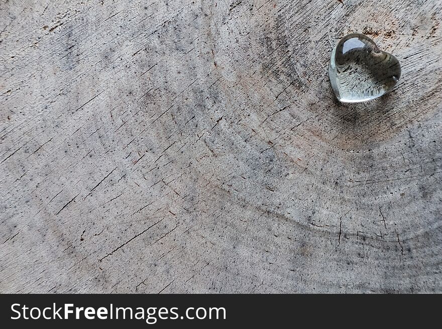 Transparent heart on the rough surface of an old stump. Perfect Valentine`s Day greeting card background.